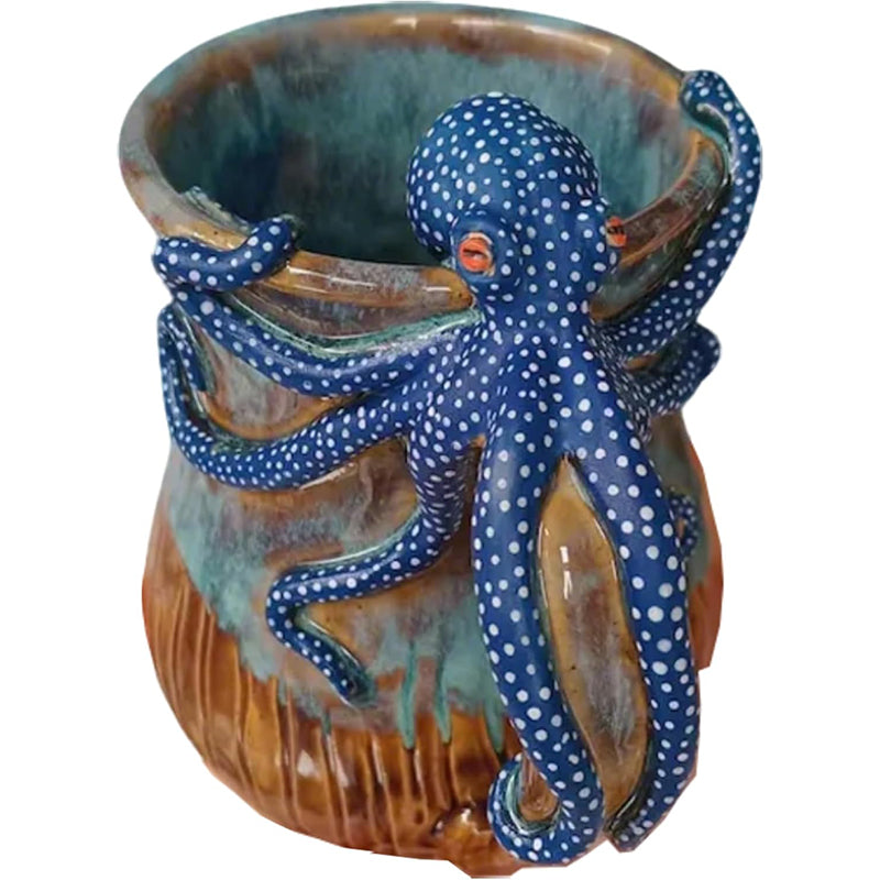 Blue octopus sculpture wrapped around a ceramic mug