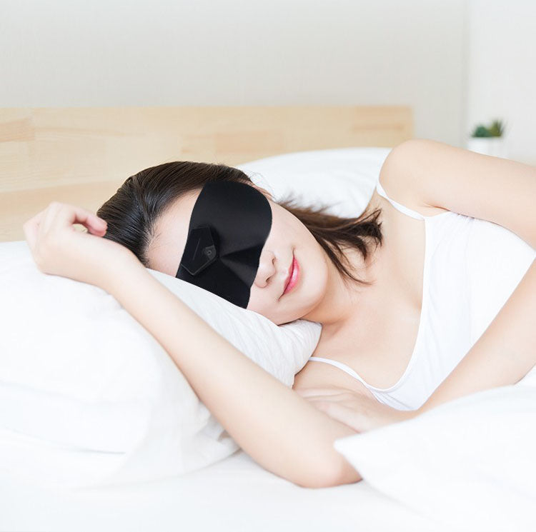 Sleeping model wearing a dark contoured eye mask