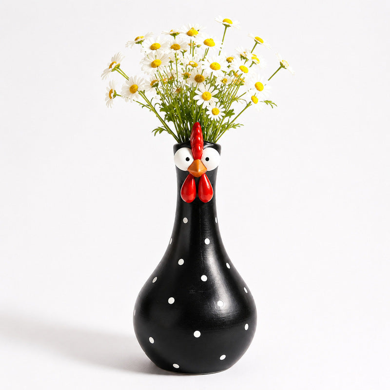 Black polka-dot rooster-shaped vase holding flowers