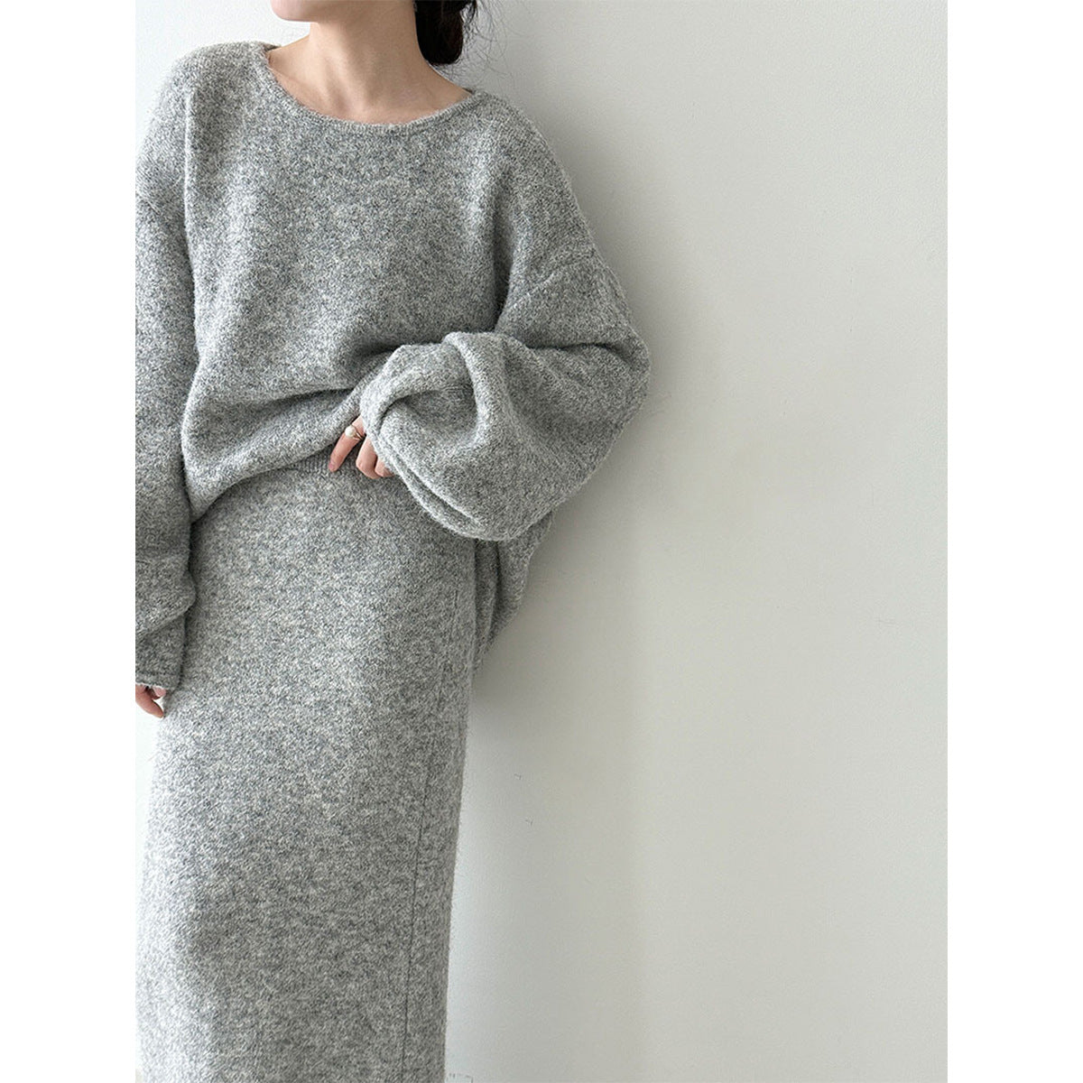 Model wearing a gray knit sweater and long skirt