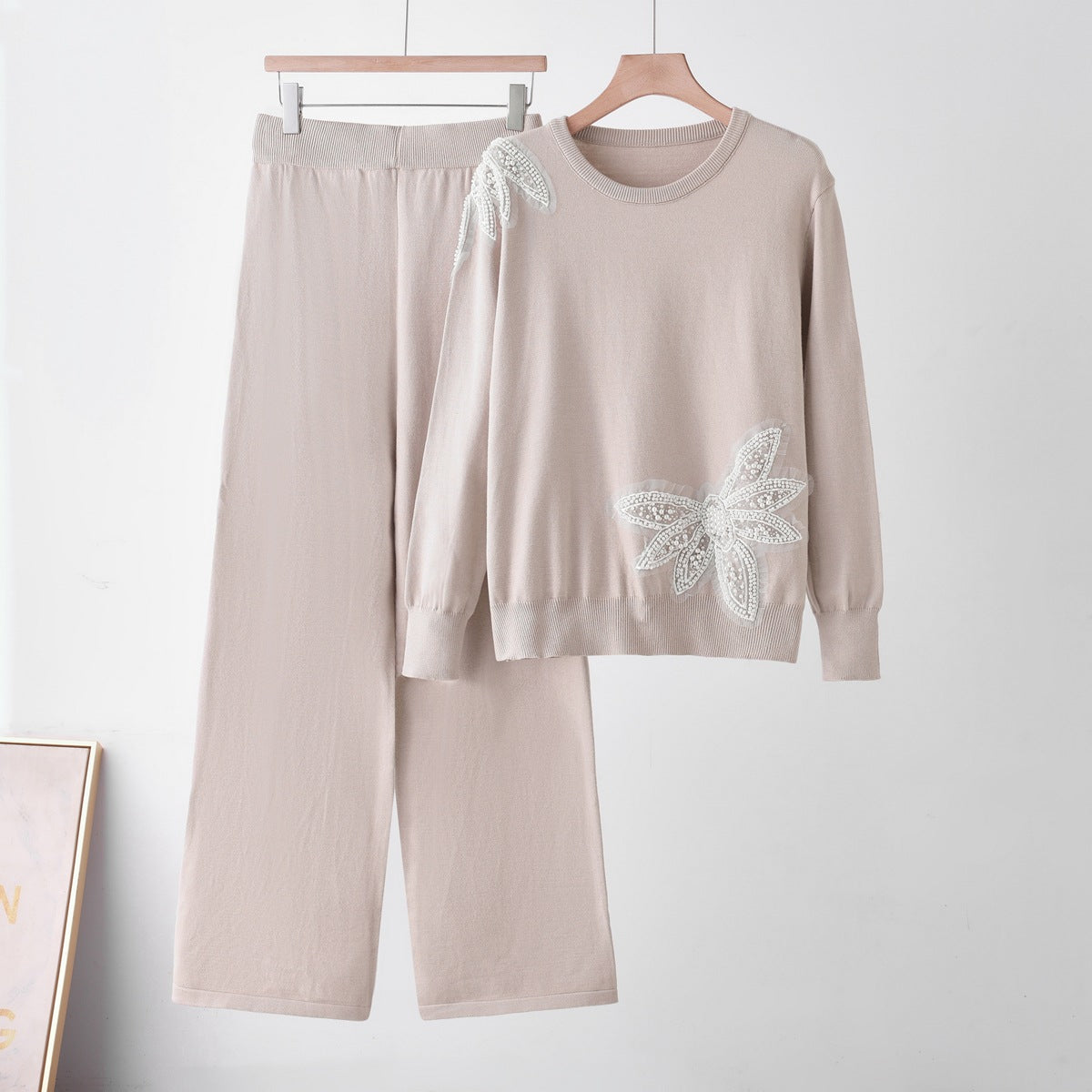 Pale knit top and matching trousers on hangers