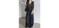 Model wearing dark high-waist wide-leg trousers