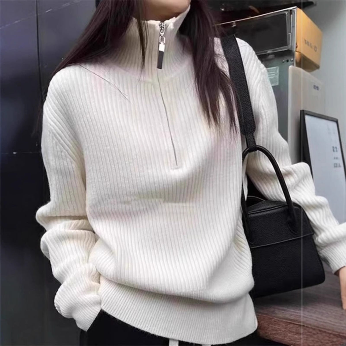 Model wearing a cream half-zip high-neck sweater