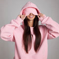 Model wearing a pink hooded top with integrated eye cover