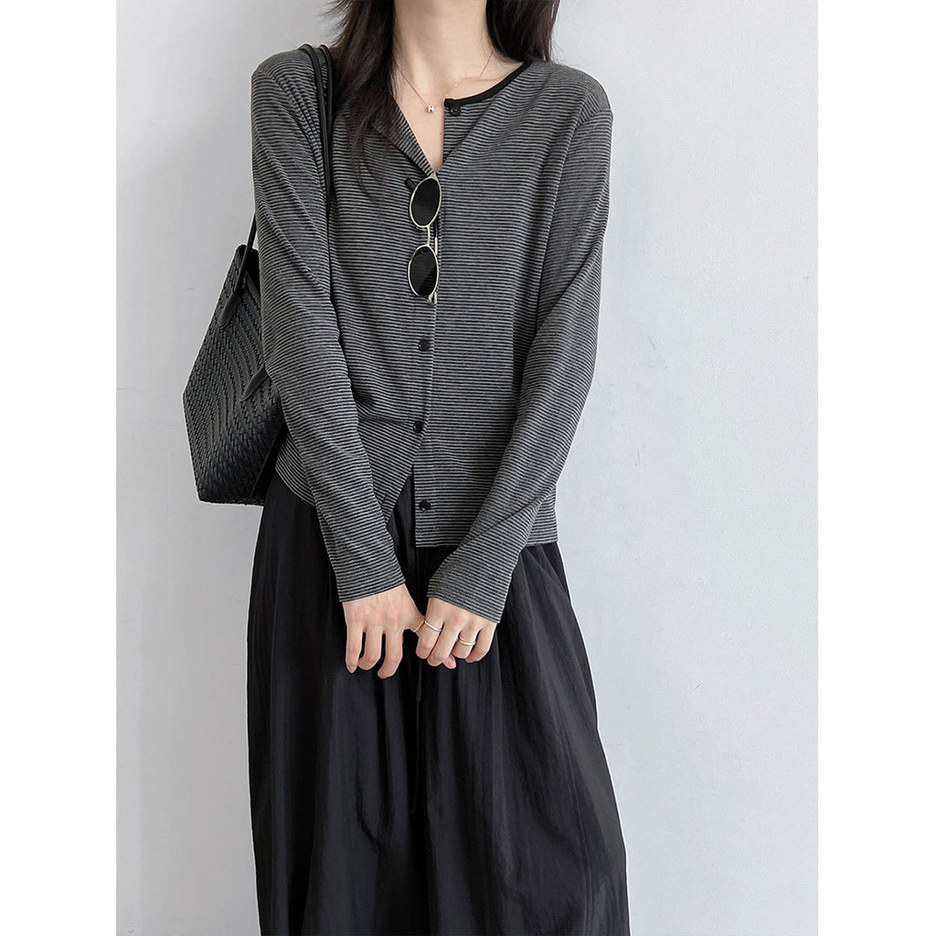 Black cardigan and camisole shown with checkered skirt