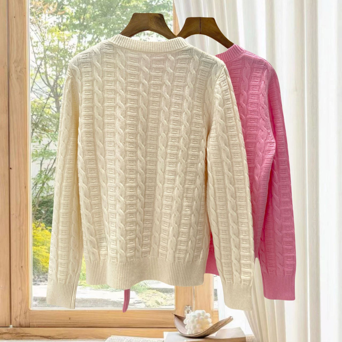 Cream cable-knit pullover with other colors behind