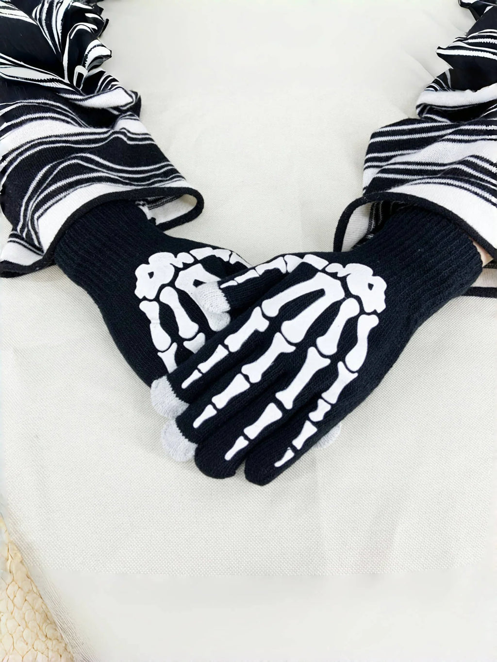 Black knit gloves with white skeleton hand pattern